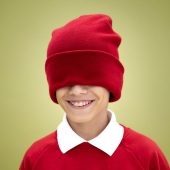 Enfant souriant avec bonnet, sensibilisation au handicap invisible chez l'enfant